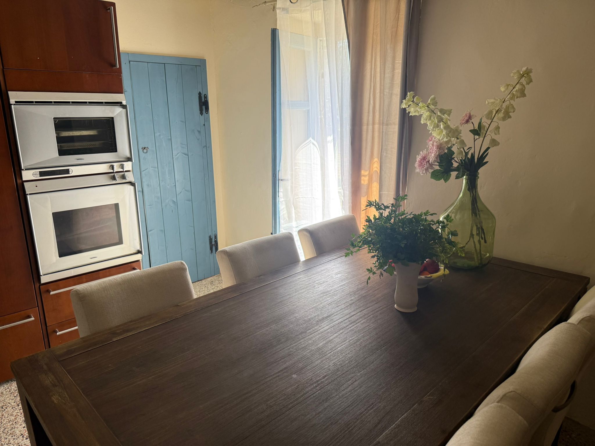 Eetkamer met blauwe deur en natuurlijk licht