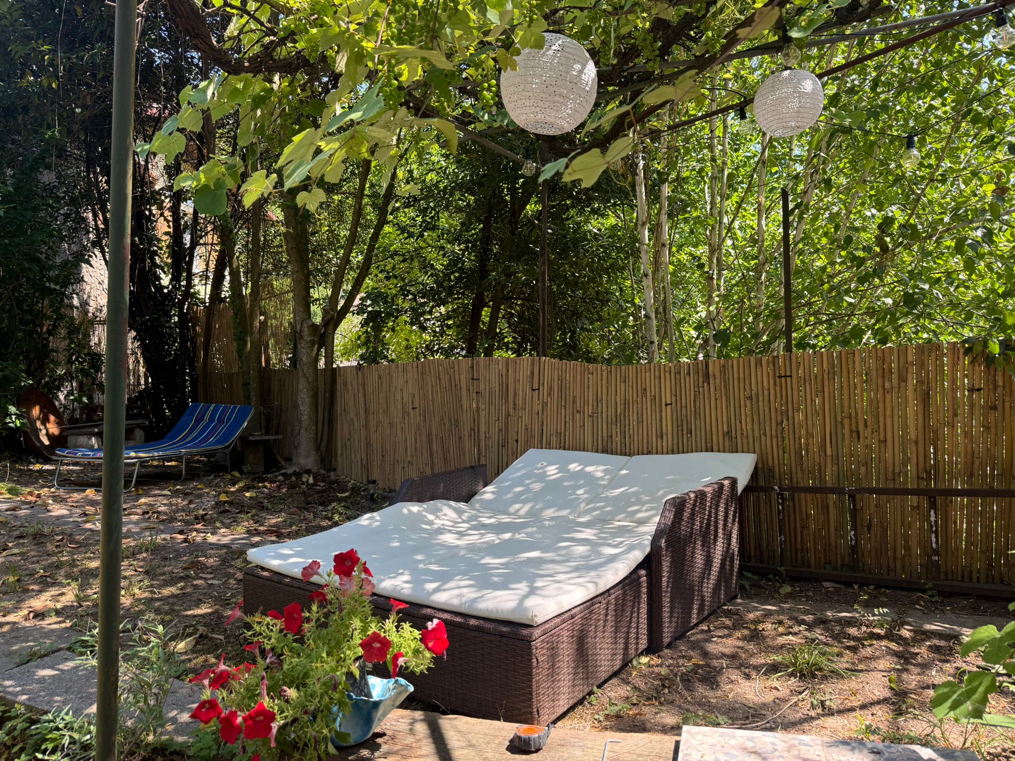 Tuin met loungebed en lantaarns